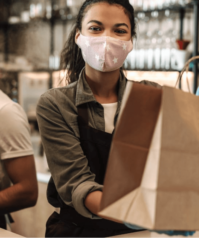 A girl shopping while wearing a face mask.